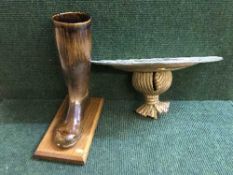 A ceramic treacle glazed boot on oak plinth and a gilt wall shelf