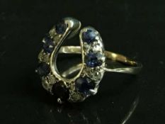 An antique horseshoe ring set with diamonds and sapphires