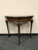 An early 20th century mahogany d-shaped card table,