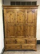 A large pine triple door wardrobe fitted with drawers,