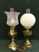 A brass oil lamp with etched glass shade and one other