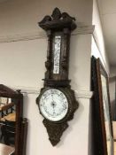 An Edwardian carved oak aneroid barometer
