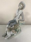 A Lladro figure - Gentleman seated with dog