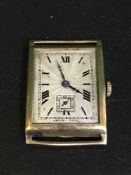 A vintage oblong gold watch, missing glass but ticking.