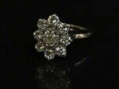 A diamond cluster ring in platinum, central stone approximately 0.