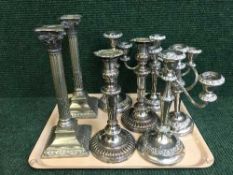 Two trays of plated four piece tea services, candlesticks, plated candelabra,