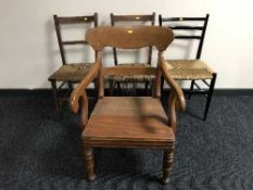A mahogany scroll armchair and three rush seated chairs