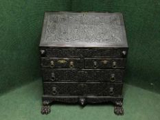 A 19th century carved oak bureau on lion paw feet,