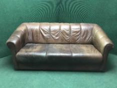 A brown leather three seater settee