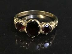 A 9ct gold three stone garnet ring