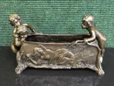 A bronze cherub planter