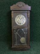 An early 20th century oak cased wall clock