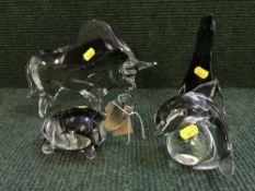 A glass figure of a buffalo and three further similar figures