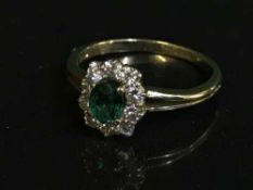 An 18ct gold diamond and emerald cluster ring, (retail receipt £2500).