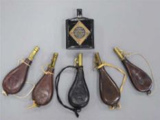 Five assorted embossed leather shot flasks, some containing lead shot,