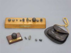 A 19th century leather powder satchel containing a quantity of lead shot,