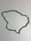 A silver and green jade necklace