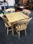 A square pine pub table and four pine chairs