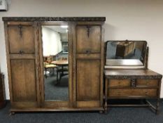 An early 20th century oak triple door wardrobe and dressing table