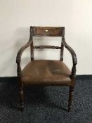 An early 19th century mahogany armchair with scroll back