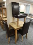 A square oak pub table and three brown leather chairs