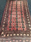 A Persian fringed rug on red ground