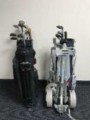 Three golf bags of clubs and a trolley