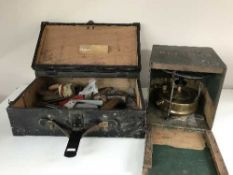 An old tool box with tools together with an antique paraffin lamp in box