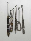 Four various early 20th century advertising button hooks, Nestle Milk,