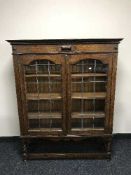 A 1920's oak glazed door bookcase