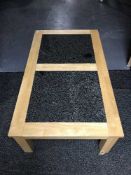 A light oak coffee table with granite inset top