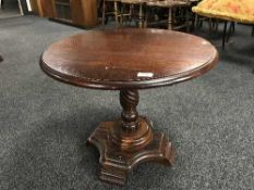 A small oak circular coffee table on pedestal base