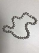 A freshwater grey pearl necklace on 14ct gold clasp
