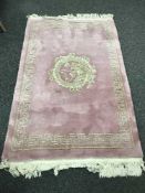 A Chinese fringed rug on pink ground