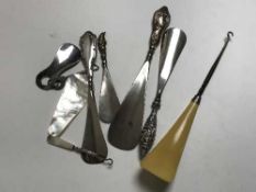 Four silver handled shoe horns including a Mr.