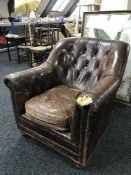 A brown leather antique style club armchair