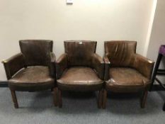 Three brown leather club armchairs