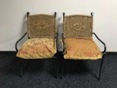 A pair of metal framed garden armchairs with cushions