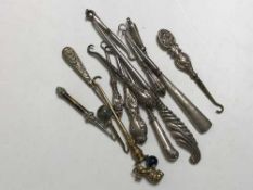 A collection of fourteen mostly silver handled button hooks,