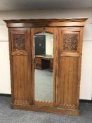 An Edwardian walnut mirror door wardrobe
