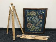 A framed floral tapestry and two artist's easels