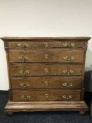 An antique oak five drawer chest on stand