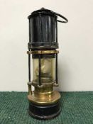 An antique brass and metal miner's lamp