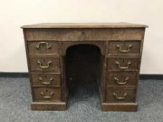 A nineteenth century oak kneehole desk with tooled leather top