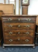 An antique mahogany four drawer chest on scroll feet