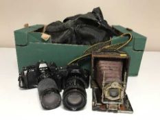 An antique camera, modern cameras by Nikon,