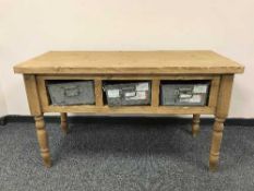 A reclaimed pine table fitted with three galvanised drawers