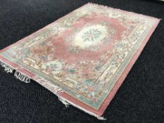 A pink Chinese fringed carpet