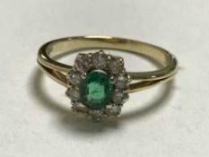 An 18ct gold diamond and emerald cluster ring, (retail receipt £2500).