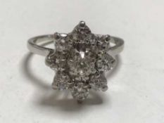A diamond cluster ring in platinum, central stone approximately 0.